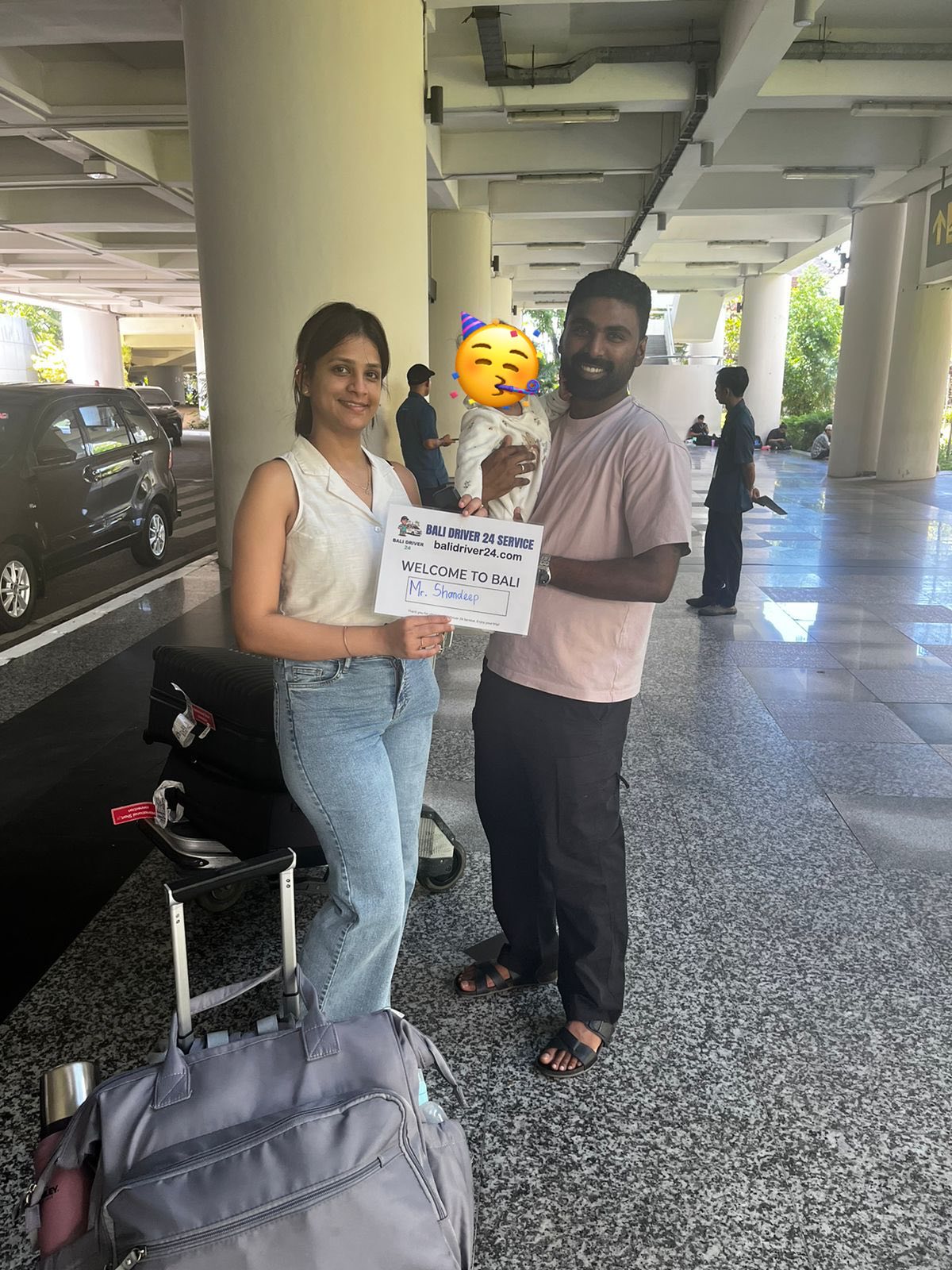 Travelers welcomed at Bali airport with a Bali Driver 24 Service sign