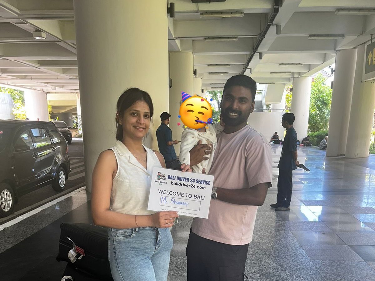 Travelers welcomed at Bali airport with a Bali Driver 24 Service sign
